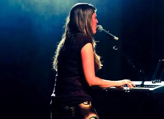 Pra. Gisele ao teclado durante um momento de adoração