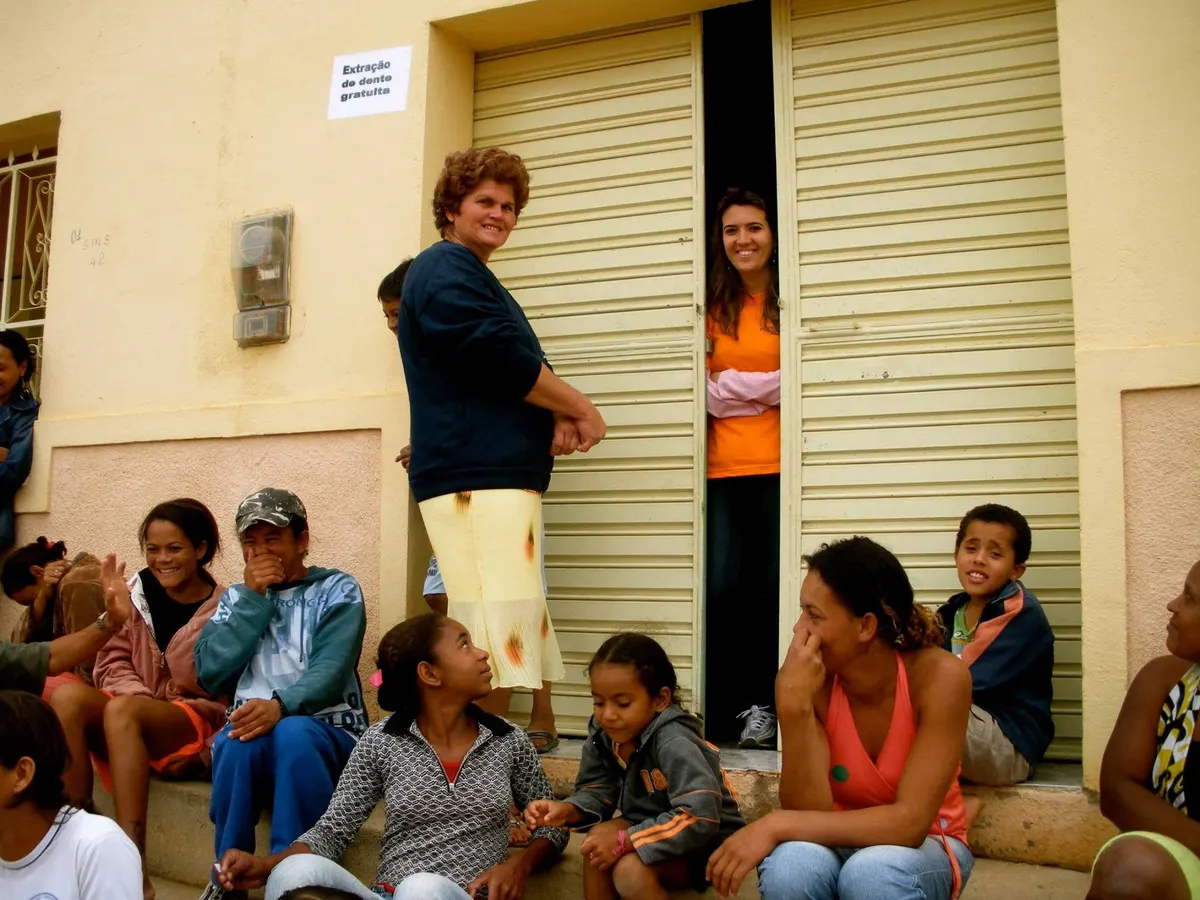 Crianças e adultos reunidos na calçada durante uma atividade comunitária