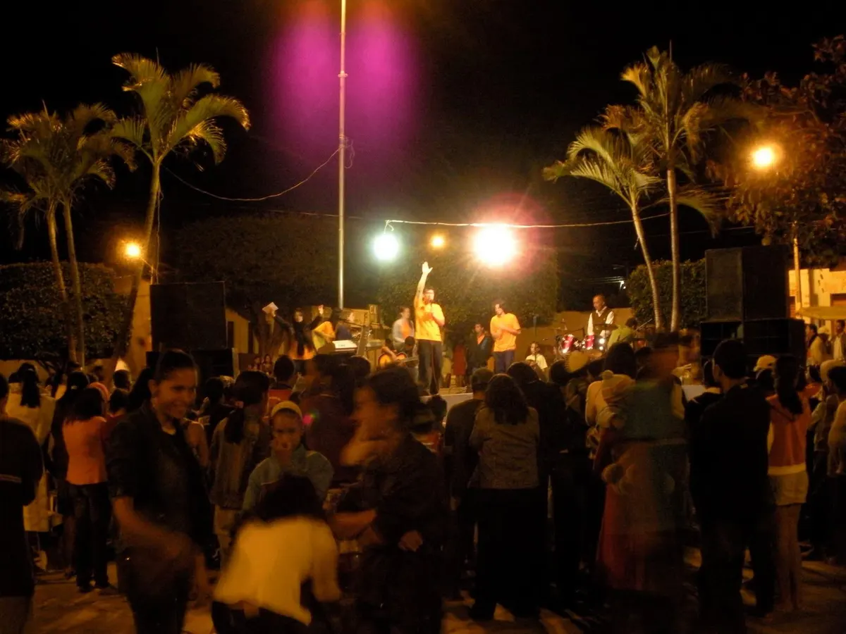 Multidão reunida em praça durante evento noturno